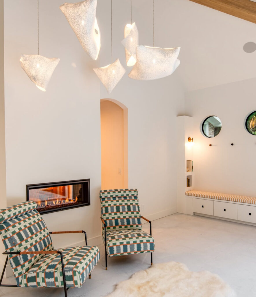 Pool house lounge with fireplace and patterned chairs