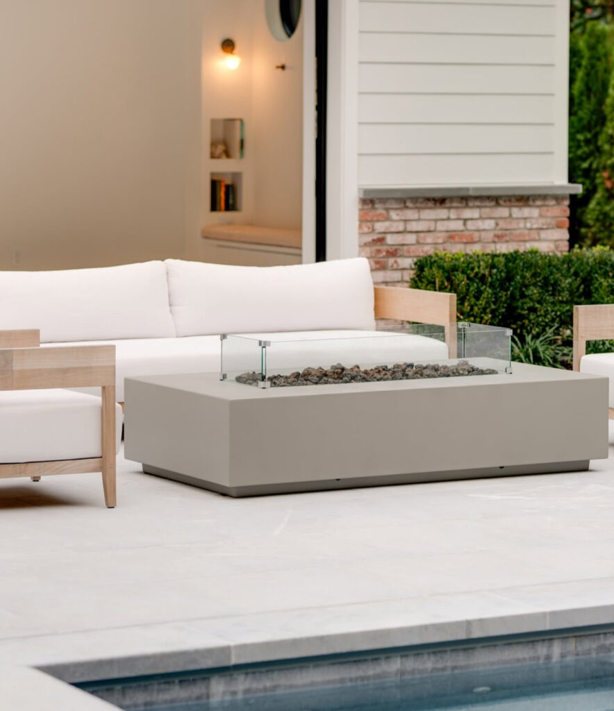 Outdoor fire table with cushioned seating beside the pool