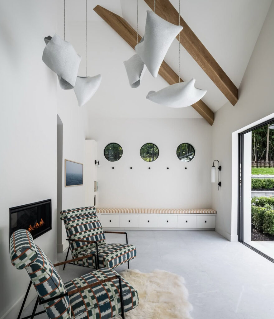 Pool house lounge with fireplace, built-in bench, and patterned chairs