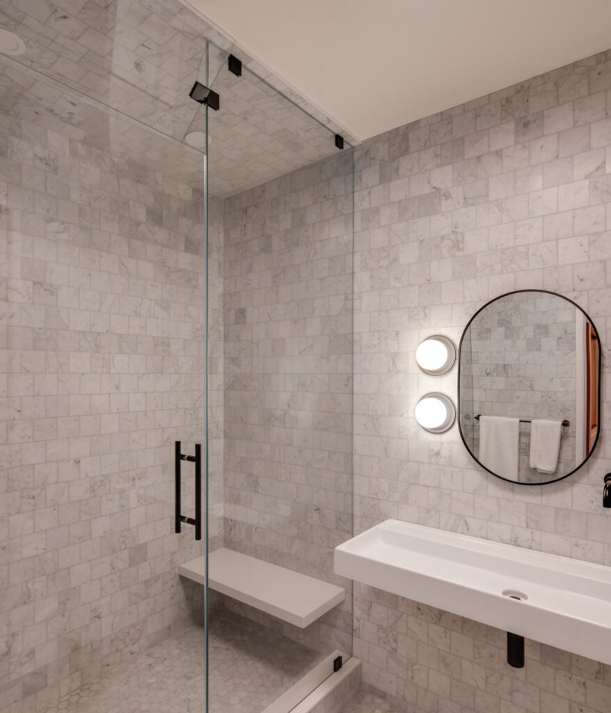Tiled shower with glass enclosure and floating sink