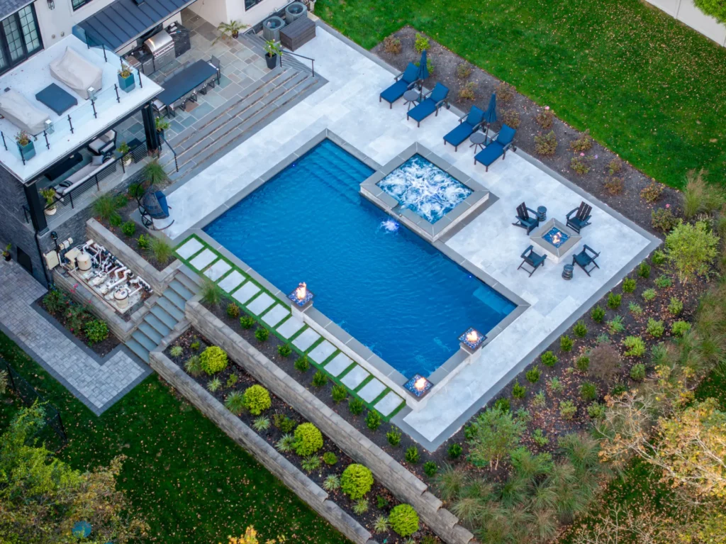 Aerial view of pool and raised spa beside an outdoor kitchen and patio