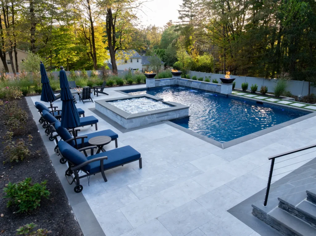 Elevated view of pool, raised spa, fire bowls, and surrounding patio seating