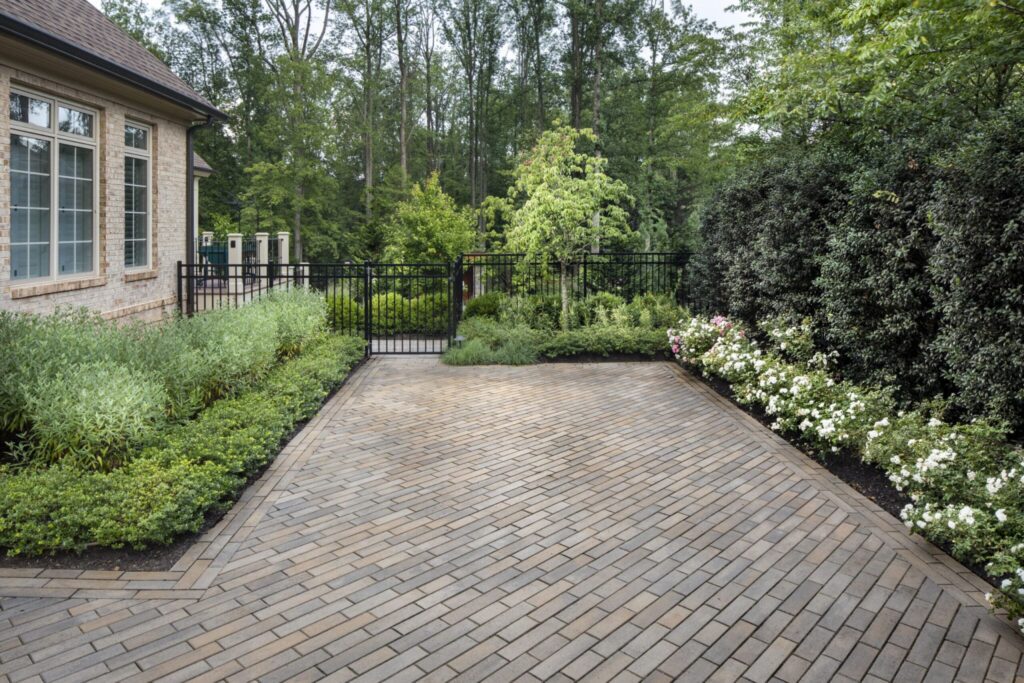 Herringbone brick courtyard framed by landscaped garden beds